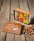 Southern BBQ Peanuts Men's Gift Tin with Texas, Memphis, and Carolina flavored 4 oz. bags on rustic wood table