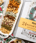 "24 Days of Nuts & Snacks Holiday Advent Calendar with assorted nuts and snacks on festive table"